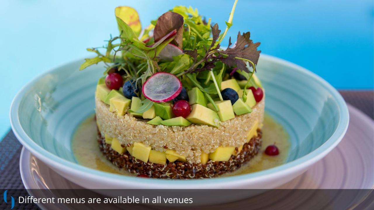 Grand Cosmopolitan Hotel Dubai Exterior foto The photo features a beautifully arranged dish that resembles a layered salad or a savory cake. It consists of various fresh ingredients, including avocado, diced mango, blueberries, and radishes, all artfully layered to create an appealing presentat
